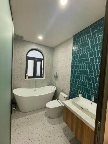 a bathroom with a tub and a toilet and a sink at Zen Village Lagi in Lagi