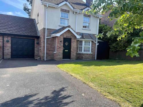a brick house with a garage and a driveway at Spacious 4 bedroom house with large garden in Belfast