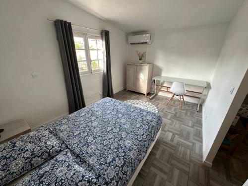 sypialnia z łóżkiem, biurkiem i oknem w obiekcie T2 à Convenance w mieście Baie-Mahault