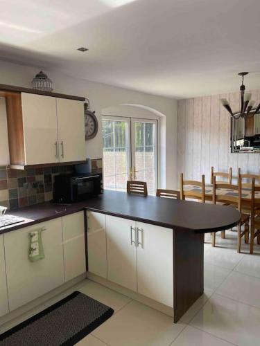 a kitchen with a table and a dining room at Spacious 4 bedroom house with large garden in Belfast