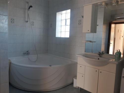 Baño blanco con bañera y lavamanos en Apartment Marija, en Pula