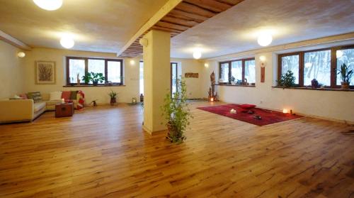 duży salon z drewnianymi podłogami i oknami w obiekcie DobroDziejnia w mieście Nowa Ruda