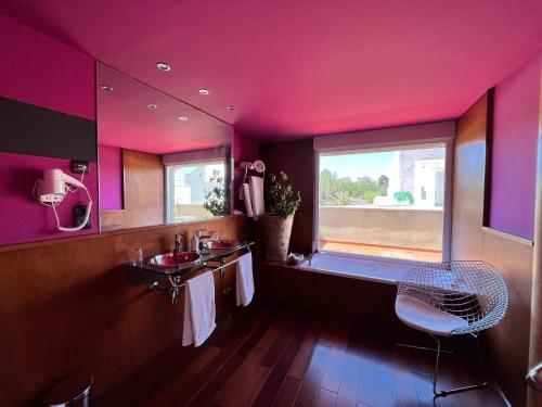 a pink bathroom with a sink and a window at PENSIÓN EL CARRO in Utiel