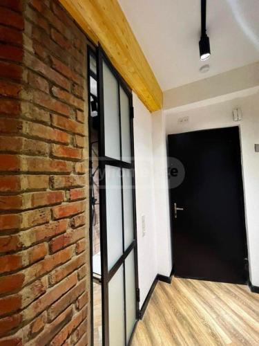 ein leeres Zimmer mit Ziegelwand und Tür in der Unterkunft Apartment in Tbilisi Dadiani 3 in Tbilisi City