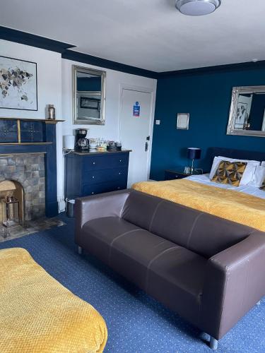 a bedroom with a bed and a couch and a fireplace at The Crown Inn - Rooms in Keynsham