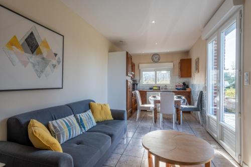 un salon avec un canapé bleu et une table dans l'établissement La Marigyptienne - Au calme à 15min de la plage, à Sainte-Marie-au-Bosc