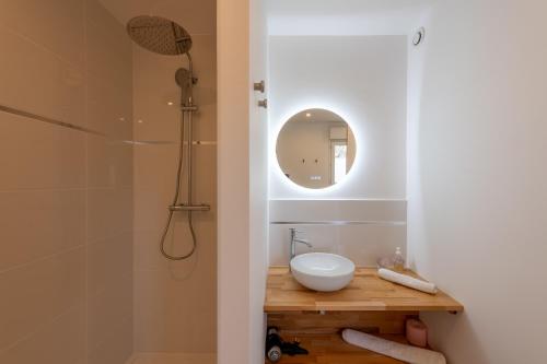 une salle de bain avec un lavabo et une douche avec un miroir dans l'établissement La Marigyptienne - Au calme à 15min de la plage, à Sainte-Marie-au-Bosc