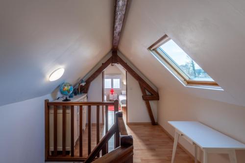 Cette chambre mansardée dispose d'un escalier et d'une fenêtre. dans l'établissement La Marigyptienne - Au calme à 15min de la plage, à Sainte-Marie-au-Bosc