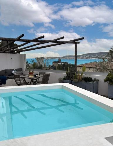 - une piscine sur une terrasse avec une table et des chaises dans l'établissement Villa avec piscine, Baie de Bandol, Accès plage, à Sanary-sur-Mer