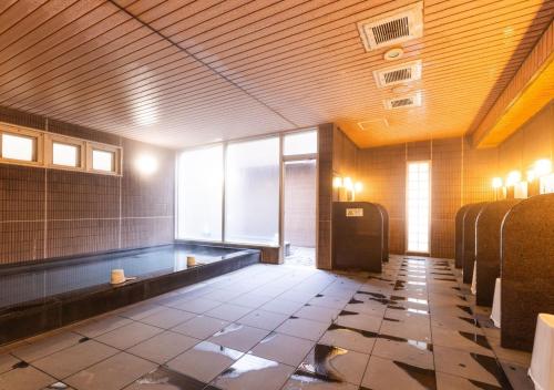 فندق إيه بي إيه نيغاتا فوروماتشي في نيغاتا: حمام فارغ مع حوض في مبنى