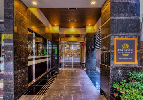 a hallway of a hotel with a sign on the wall at APA Hotel Niigata Furumachi in Niigata
