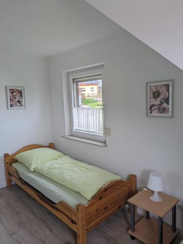 a bedroom with a bed and a window at Ferienwohnung Haus Ella in Neunkirchen