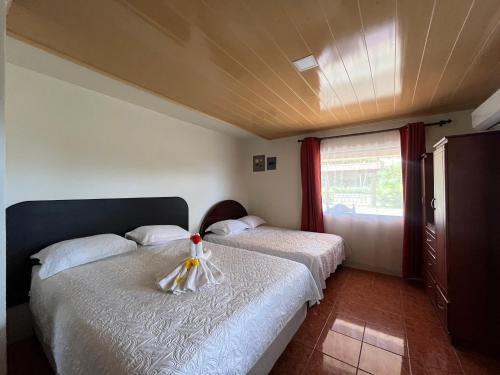 1 dormitorio con 2 camas y ventana en Casa La Finca Private Pool / AC WiFi 300Mbps, en Fortuna