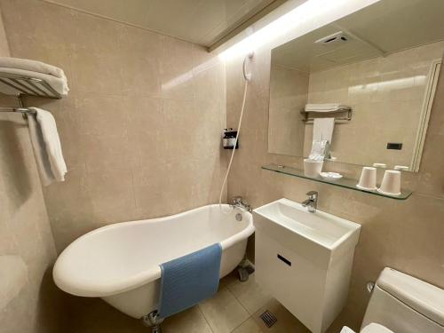 uma casa de banho com uma banheira, um WC e um lavatório. em 新仕飯店-New City Hotel em Taipei