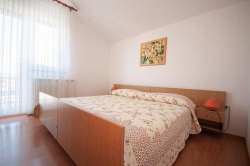 a small bedroom with a bed and a window at Apartment Anita in Pula