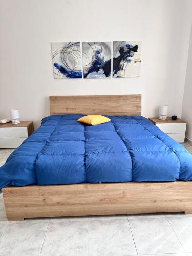een bed met een blauw dekbed in een slaapkamer bij Pamir Casa Vacanze Appartamento in Trapani