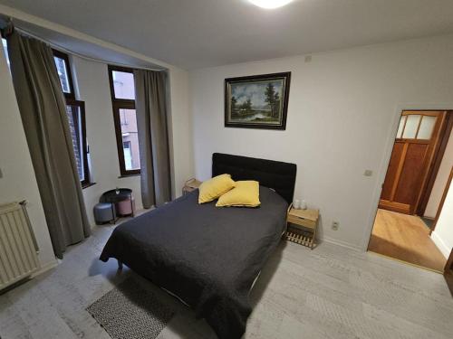 a bedroom with a bed with two yellow pillows on it at Beautiful, renovated fully self contained room in Brussels