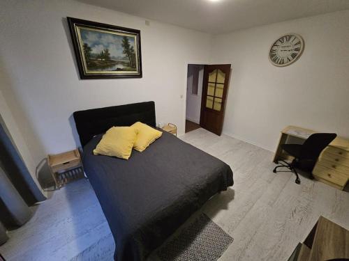 a bedroom with a bed and a clock on the wall at Beautiful, renovated fully self contained room in Brussels