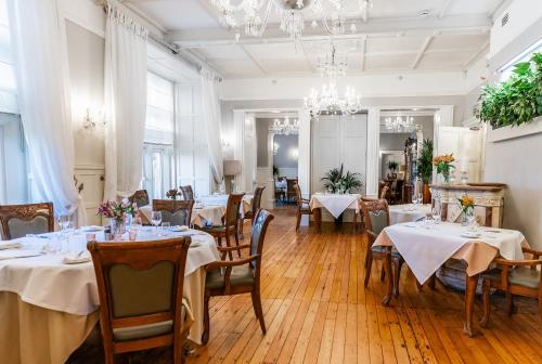 un comedor con mesas y sillas y una lámpara de araña en Berwick Lodge, en Bristol