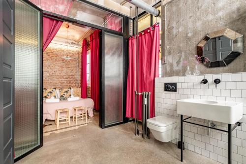 a bathroom with a sink and a toilet and a bedroom at Charming Puerta de Alcalá in Madrid