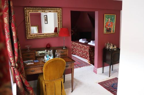 a bedroom with a desk and a mirror and a bed at The George Inn in Windsor