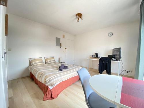 une chambre avec un grand lit et une table dans l'établissement Petit Studio Corot St jacques, à Clermont-Ferrand
