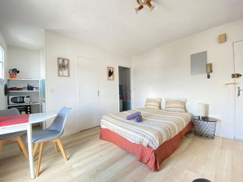 une chambre avec un lit, une table et un bureau dans l'établissement Petit Studio Corot St jacques, à Clermont-Ferrand
