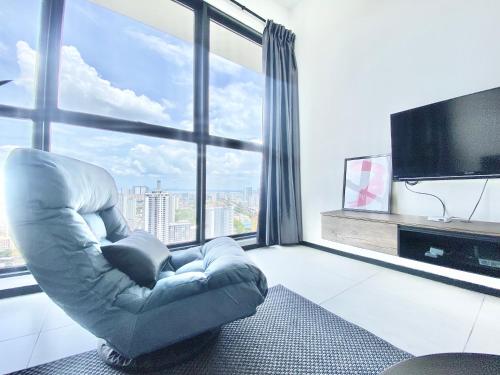 a living room with a chair in front of a large window at Urban Suites #High floor view #Infinity Pool #Georgetown #4pax #2BR 2bath #2 Queen #Quality well maintained #Private host in Jelutong