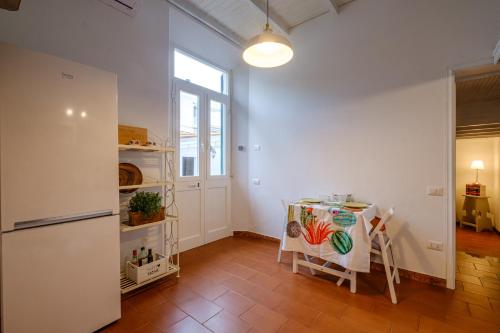 uma cozinha com uma mesa e um frigorífico em Giardino al Mare em Forte dei Marmi