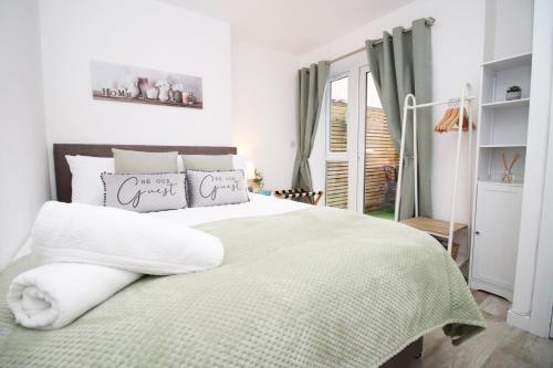 a bedroom with a large bed with a green blanket at Luxury Apartment in Cardiff