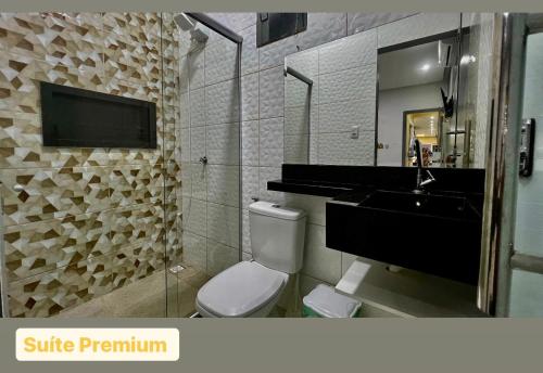 a bathroom with a toilet and a sink and a mirror at Casa Exclusive Salinas Atalaia in Salinópolis