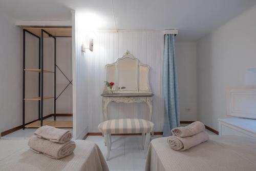 um quarto branco com 2 camas e um espelho em Giardino al Mare em Forte dei Marmi