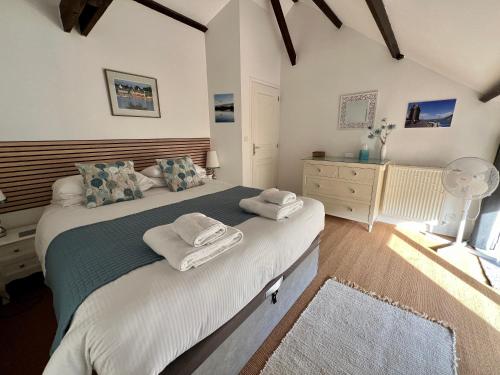 um quarto com uma cama grande e toalhas em Quai Du Val, A Stunning Property With River View em Léhon