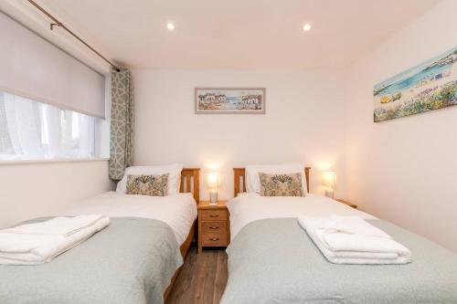 - 2 lits jumeaux dans une chambre aux murs blancs dans l'établissement The Seaside Haven W Parking - Mins To Viking Bay, à Kent