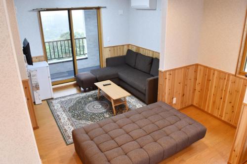 a living room with a couch and a table at 美ら海　みるきぃうえぃ in Motobu