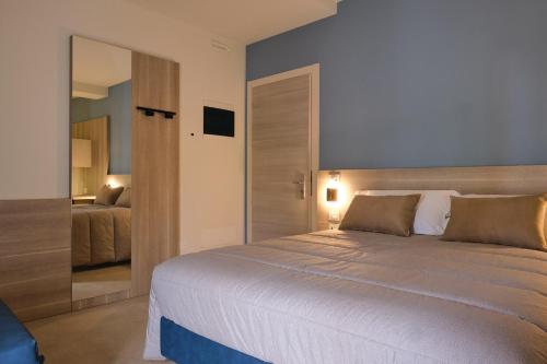 a bedroom with a large bed and a mirror at Al Bacino Rooms And Breakfast in Porto Viro