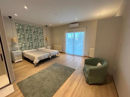 a bedroom with a bed and a chair and a window at La Casa del Tejado Verde Toledo in Toledo