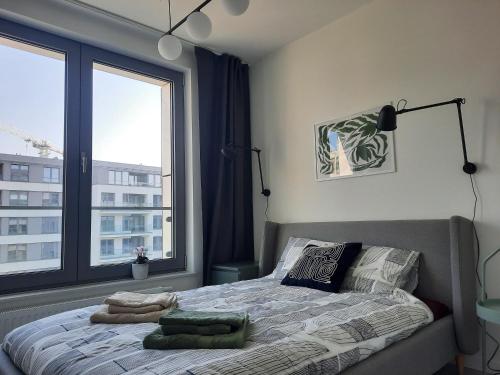 a bedroom with a bed with a large window at APARTAMENTY Z MORZA I MARZEŃ in Gdynia