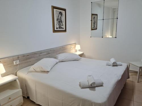 1 dormitorio con 1 cama blanca grande y toallas. en Casa Natalia, en Armeñime