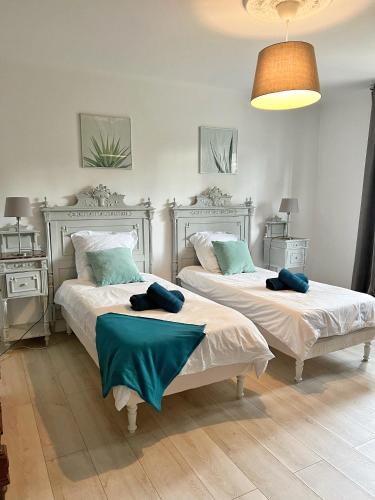une chambre avec deux lits avec des oreillers bleus dessus dans l'établissement Villa avec piscine, Baie de Bandol, Accès plage, à Sanary-sur-Mer