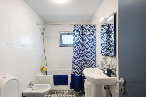 a bathroom with a sink and a toilet and a tub at MAISON DE VACANCES AVEIRO in Gafanha da Nazaré