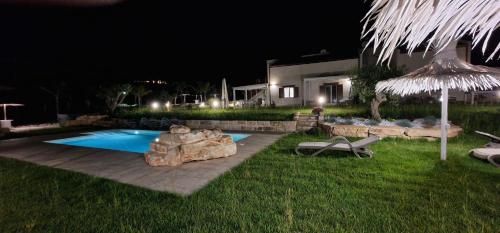 a backyard with a swimming pool at night at Appartamento Limone in Splendida villa Nature al mare di Scopello Zingaro in Scopello