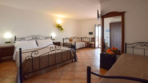 1 dormitorio grande con 2 camas y comedor en Agriturismo Le Agavi, en San Mauro Cilento