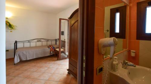 a bathroom with a bed and a tub and a sink at Agriturismo Le Agavi in San Mauro Cilento