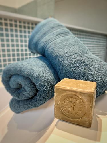 - une serviette et un réveil au-dessus du comptoir de la salle de bains dans l'établissement Villa avec piscine, Baie de Bandol, Accès plage, à Sanary-sur-Mer