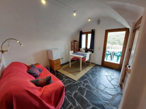 a living room with a red couch and a desk at Cala Clareta in Castellfollit de la Roca