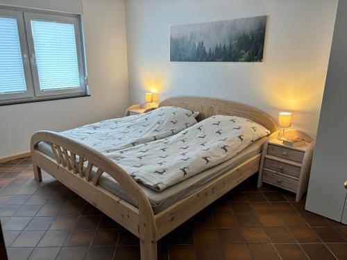 a bed in a bedroom with two night stands and two lamps at Landhaus Reppel in Bad Laasphe