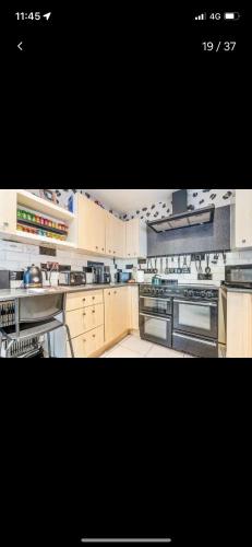 a large kitchen with white cabinets and appliances at Quatford hideaway in Quatford