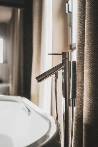 a bathroom sink with a faucet next to a window at Les Lodges Sainte-Victoire Hotel & Spa in Aix-en-Provence