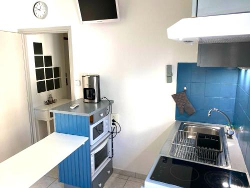 une petite cuisine avec un évier et une cuisinière dans l'établissement Studio cœur de ville à deux pas de la grande plage des Sables d'Olonne, à Les Sables-dʼOlonne